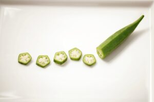 A piece of partially sliced okra on a white plate